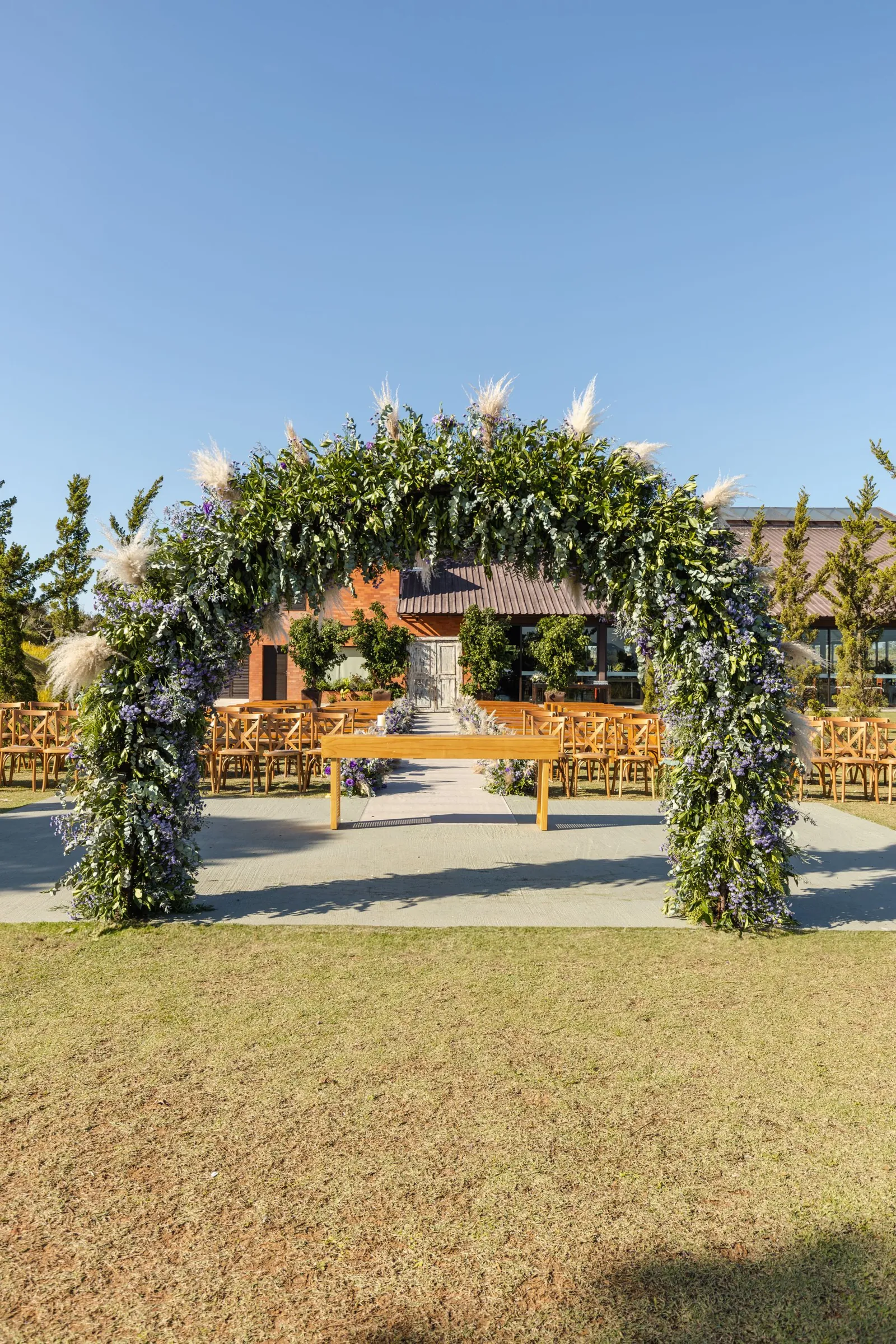 The Glenwood: a greenery and white floral arch on a lawn